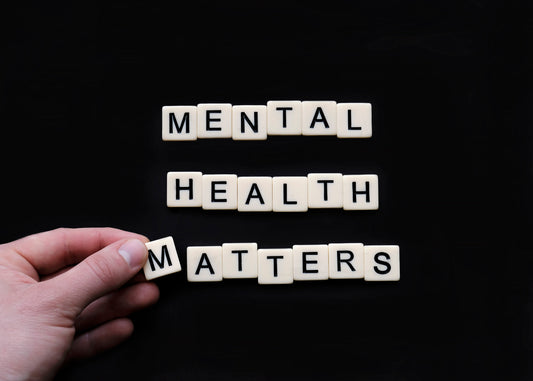 White tiles sitting on black background spelling out Mental Health Matters